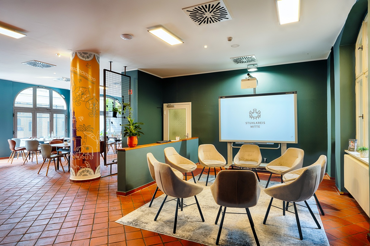 Raum mit Kreisbestuhlung aus bequemen Sesseln und Whiteboard