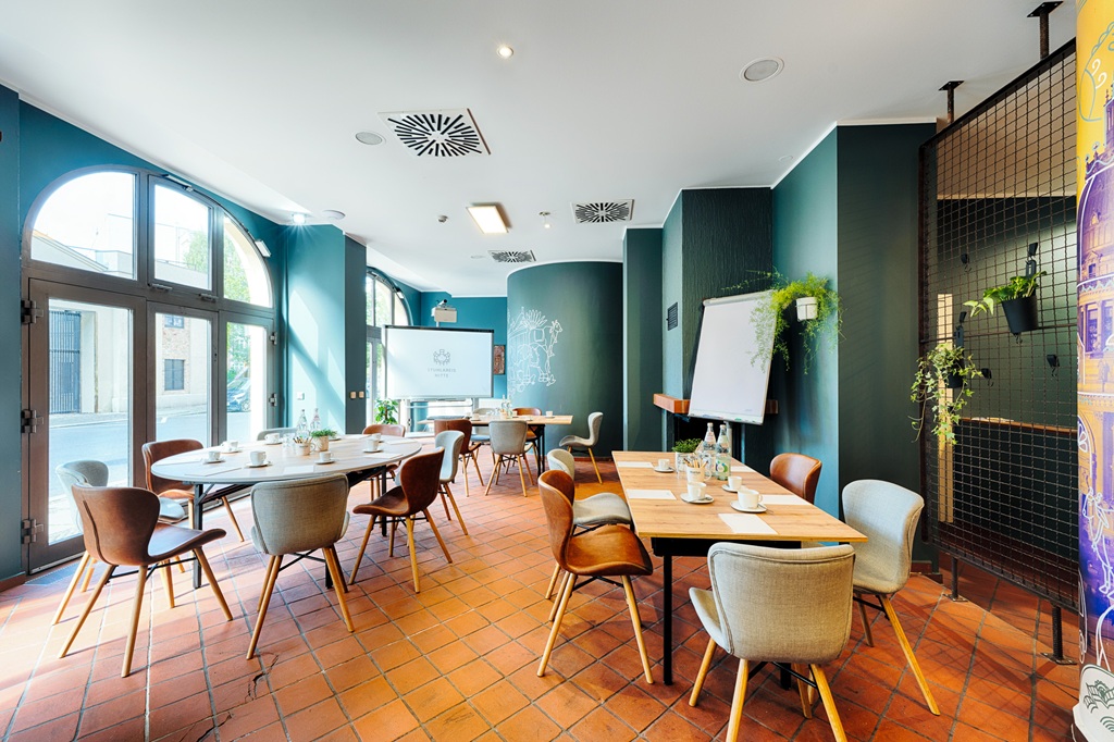 Raum mit bodentiefen Fenstern, Blockbestuhlung mit drei Tischen und Whiteboard