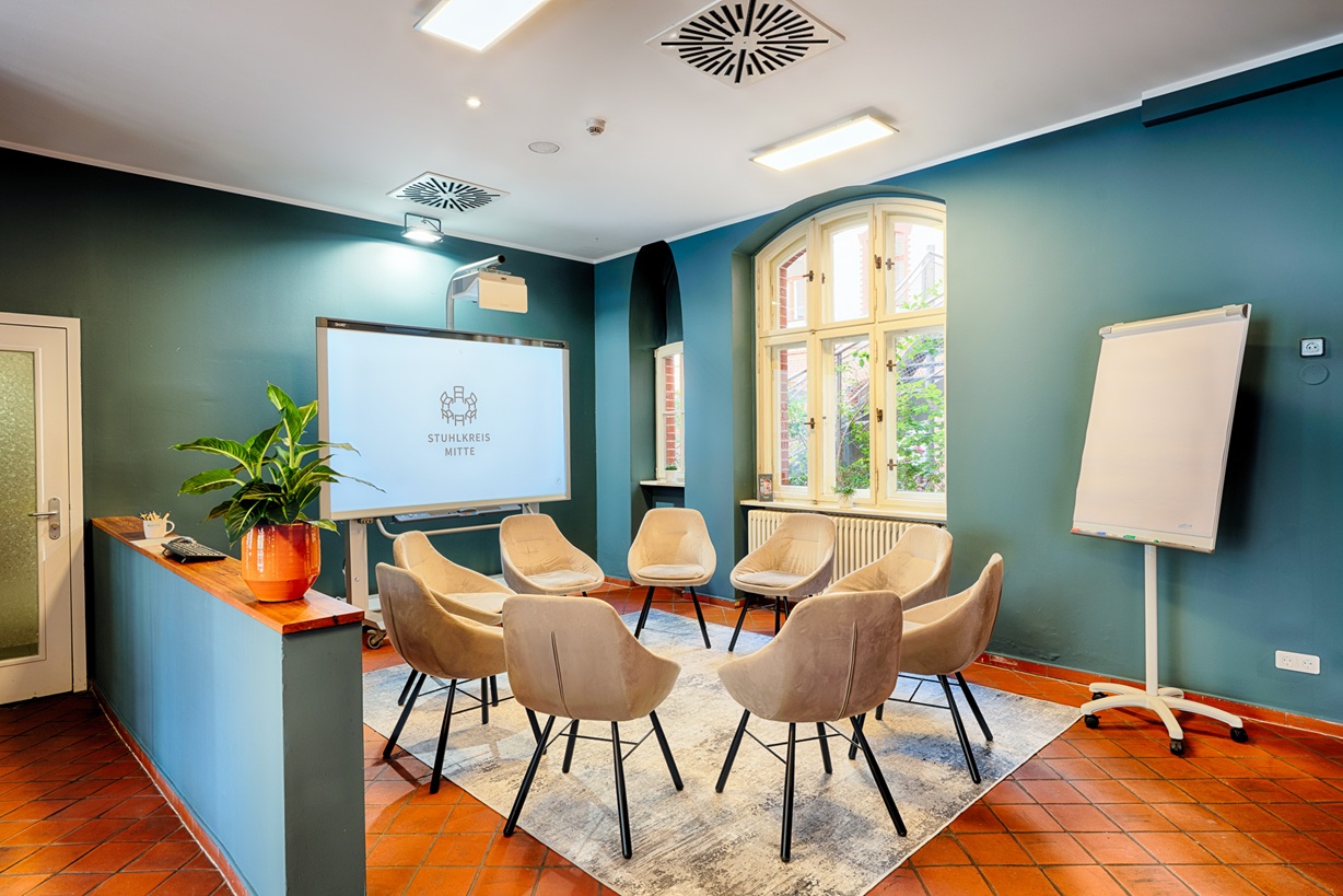 Stuhlkreis mit Sesseln sowie Whiteboard